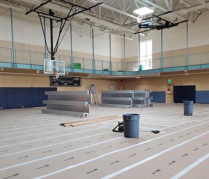 gymnasium flooring covered by protective layer so that the restoration team can begin fire restoration work