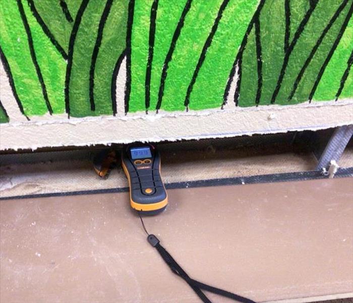 Inspecting before demolition with moisture meter in wall