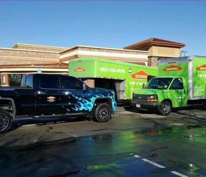 Blue truck and green truck box parked in front a facility